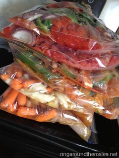 plastic bags filled with vegetables sitting on top of a stove