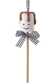 a wooden stick with a face on it and a bow tie around the top of it