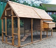 a small wooden chicken coop in the yard