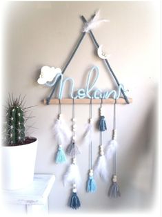 a wooden sign that says melani hanging from a wall next to a potted cactus