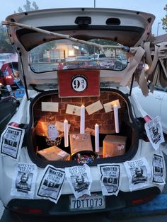 the trunk of a car with candles in it and pictures on the back, all taped together