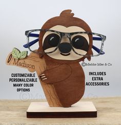 Each eyeglass stand comes standard with one (1) complementary microfiber eyeglass pouch, one (1) black leatherette eyeglass lanyard and five (5) Zeiss lens wipes. This adorable layered wood 3D Sloth eyeglass stand is a lovely gift that will be cherished for a lifetime! By adding an engraved message to the bottom of the eyeglass stand, you can add another element and memory that will be cherished forever. This cute fashionable Sloth eyeglass stand is a unique piece of decor that is stylish and fu Eyeglass Stand, Eyeglass Holder Stand, Wood 3d, Sloth Gift, Eyeglass Holder, Wearing Glasses, Tree Branch, Organza Bags, Sloth