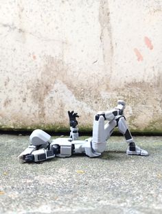 a robot laying on the ground next to a wall