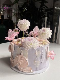 a cake decorated with flowers on top of a table