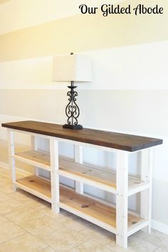 a white and wood table with a lamp on top