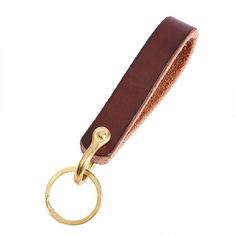 a brown leather keychain with a gold metal ring on it's end