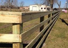 a wooden fence in the middle of a field