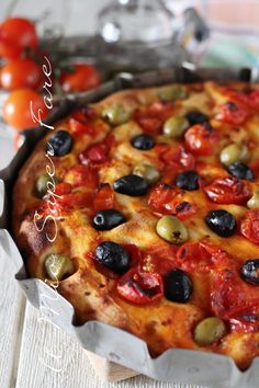 a pizza with olives and tomatoes on it