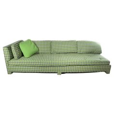 a green and black checkered couch with two pillows on top of it's back