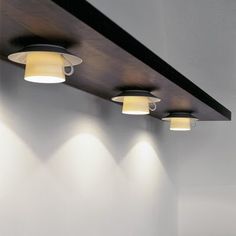 three spotlights are on the ceiling in an empty room