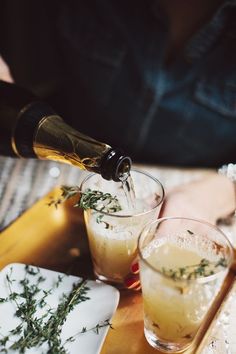 two glasses filled with drinks sitting on top of a wooden tray