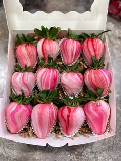 a box filled with pink and white striped strawberries