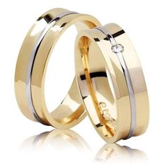 two gold wedding rings with diamonds on the inside and outside, against a white background