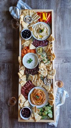 a platter filled with different types of dips, crackers and sauces