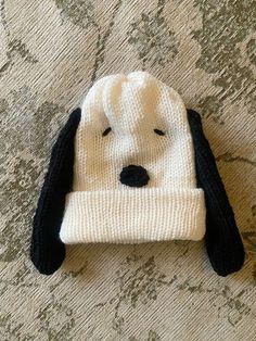 a knitted dog hat laying on top of a bed