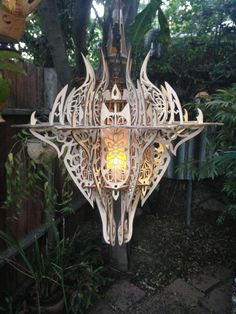 an intricately designed light fixture hanging from a tree