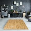 an image of a living room setting with black and white decor on the walls, wood flooring and rugs