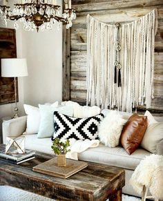 a living room filled with furniture and a chandelier hanging over the couches