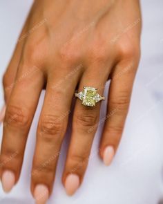 a woman's hand with a yellow diamond ring