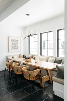 a dining room table with six chairs and a bench in front of the couches