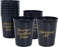 a set of six black plastic cups with gold lettering on the bottom and sides,