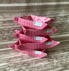 four pink paper bags stacked on top of each other