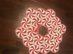 a red and white doily sitting on top of a wooden floor