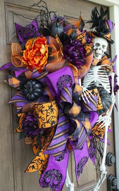 a wreath decorated with purple, orange and black decorations