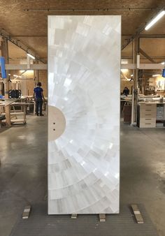 a large white sculpture sitting inside of a building next to workers working on it's walls