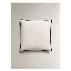 a white pillow with black piping on it