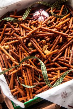 a box filled with lots of pretzels next to a christmas ornament