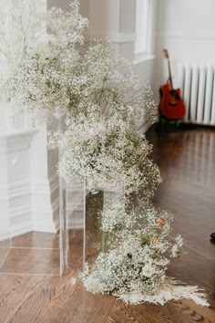 a vase filled with baby's breath flowers sitting on top of a wooden floor