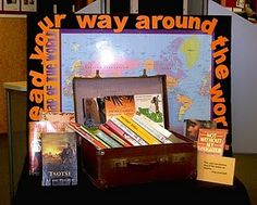 an open suitcase sitting on top of a table next to books and pamphlets in front of a map