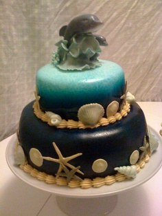 a three tiered cake decorated with sea shells