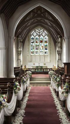 the aisle is decorated with flowers and ribbons