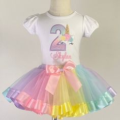 "This Personalized Girls Unicorn Birthday Shirt will be perfect for her special day. Detailed with pastel rainbow colors to go perfect with a magical unicorn themed party, You can customize it was ANY AGE 1-9 and NAME. I offer the shirt and tutu separately. Or you can purchase the full outfit. Please select in the \"options\" menu prices do vary. I offer short and long sleeve shirts. SS = Short Sleeve LS = Long Sleeve I use AJ BLANKS a Boutique quality shirt for all embroidery. They have PUFF sl Unicorn Birthday Shirt, T Shirt Unicorn Birthday, Custom Unicorn Birthday Shirts, Unicorn Eyelashes, Unicorn Birthday Outfit, Birthday Unicorn Print Crew Neck T-shirt, Affordable Unicorn Print T-shirt For Birthday, Tulle Material, Unicorn Shirt