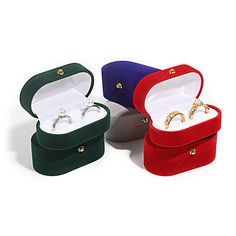 three different colored velvet jewelry boxes with gold rings in one box and silver ring on the other