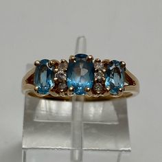 14k Yellow Gold Natural Swiss Blue And Diamond Pyramid Band Ring Size 6.5 Set Securely Across The Top Of The Ring Are Alternating Blue Topaz And Diamonds. There Are Three Oval Shape Blue Topaz And Three Small Diamonds Set Between Each Gemstone. The Topaz Have A Medium Swiss Blue Color And Are Set With Four Prongs Each. The Center One Measures 6 X 4mm And The Two Outside Ones Measure 5 X 3mm Each. The Diamonds Are Small Promotional Quality But Are Natural And Still Have Some Sparkle. The Stones Span 1/2" From Side To Side. The Band Has A Shiny High Polished Finish That Would Be Easy For Your Local Jeweler To Size. 2.7 Grams. Plenty Of Gold. Good For Any Age. It Is Solid Yellow Gold And Is Sta Swiss Blue Topaz, Solid Yellow, Womens Jewelry Rings, Pyramid, Band Ring, Oval Shape, Blue Topaz, Band Rings, Topaz