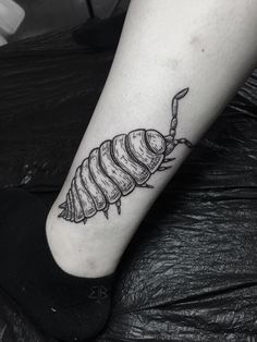 a black and white photo of a caterpillar tattoo on the foot with a knife in it