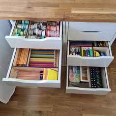 the drawers are open to reveal different colored pencils