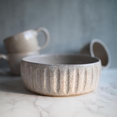 two white bowls sitting on top of a marble counter