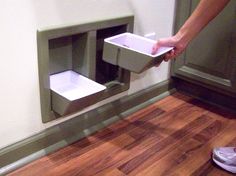 a person holding two white dishes in front of a wall mounted toilet paper dispenser