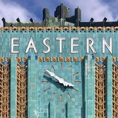 a clock on the side of a building that says eastern with scaffolding around it