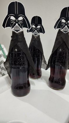 three star wars soda bottles with darth vader's faces on them sitting on a counter