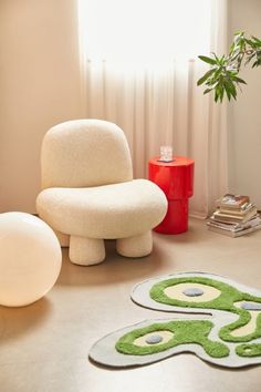 a living room with white furniture and green rugs on the floor in front of a window