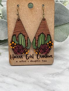 the earrings are made from wood and have flowers on them, with wooden backings