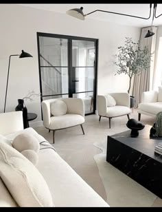 a living room with white furniture and black accents