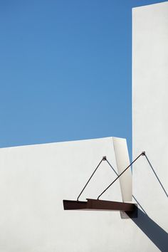 an abstract sculpture on the side of a building with a blue sky in the background