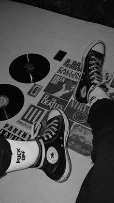 a person standing on top of a white floor next to various records and stickers