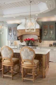 a kitchen with an island and two chairs in front of the counter top, surrounded by blue cabinets